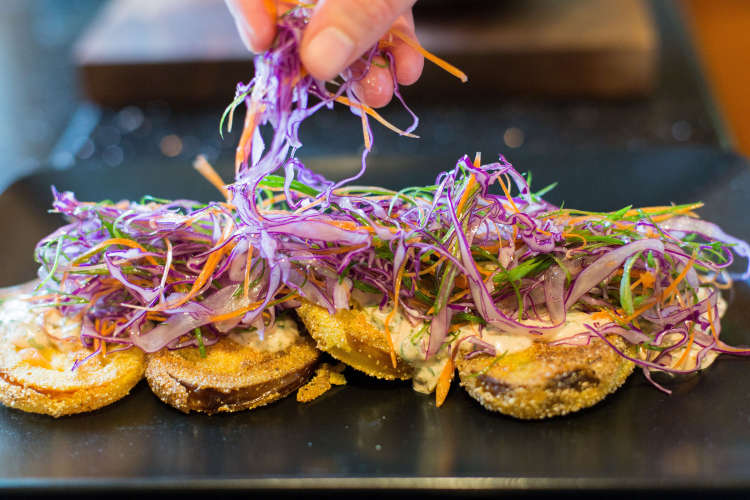 private chef plating cabbage over fried green tomatoes