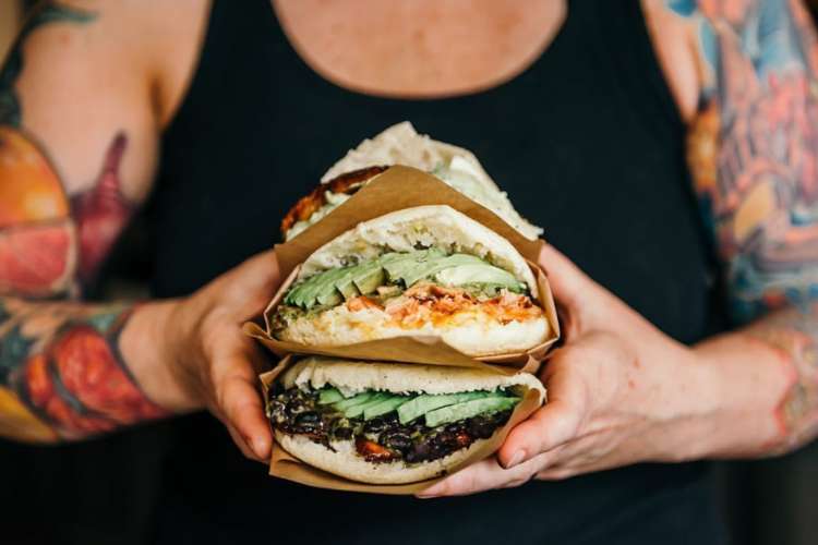 a man holding out Venezuelan arepas