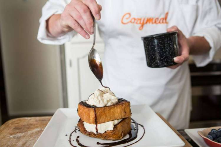 a chef drizzles chocolate over a homemade ice cream sandwich