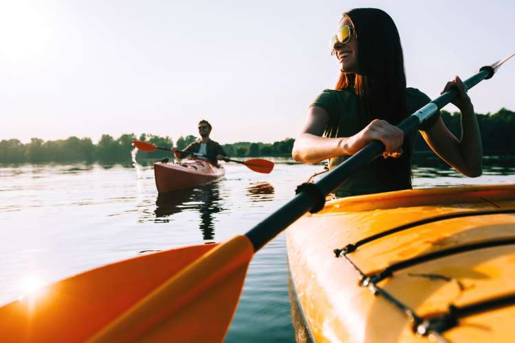 people in kayaks on a lake on a sunny day