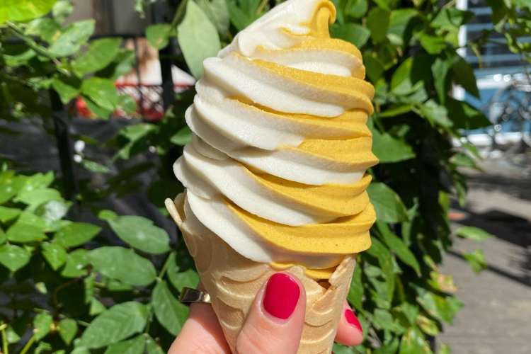 orange and white swirled ice cream in a cone