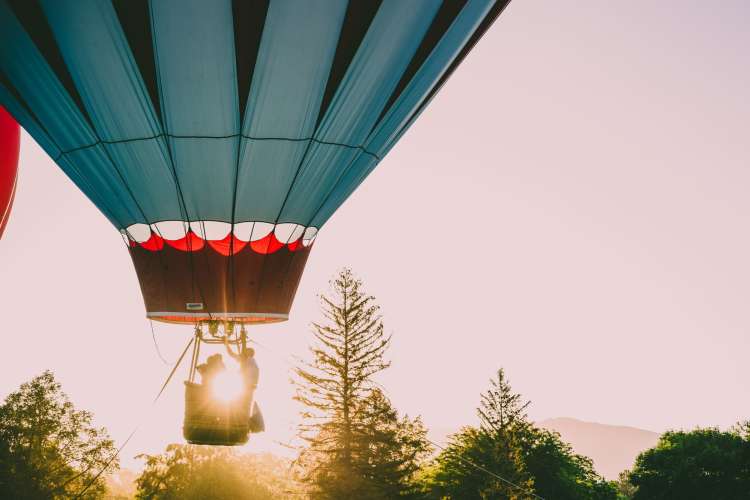 a hot air balloon in the sky carrying two people