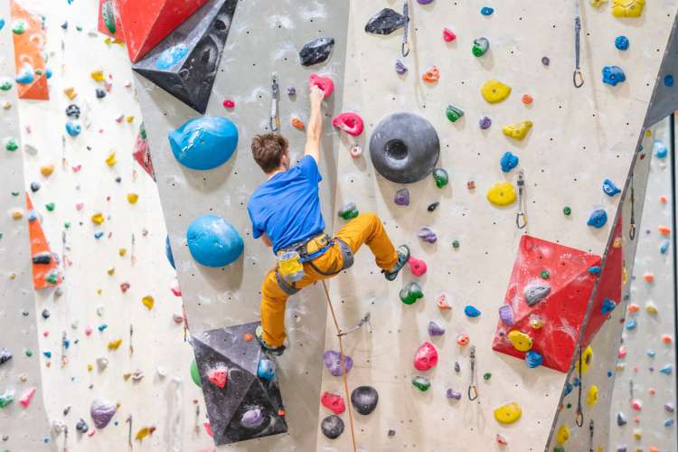 a man climbs an indoor rock-climbing wall