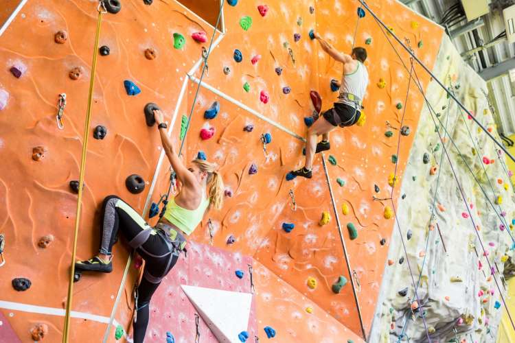 Two people rock climbing indoors during a team building activity in Las Vegas