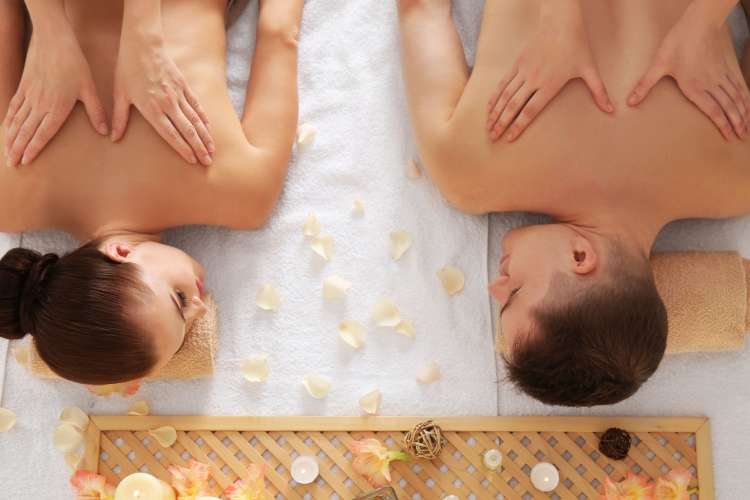 A woman and man receiving a couples massage — a great one-year anniversary date idea
