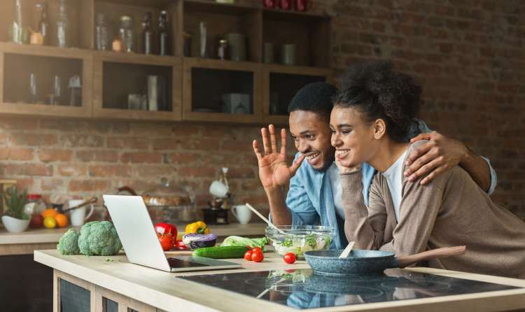 young couple in the kitchen taking an online cooking class