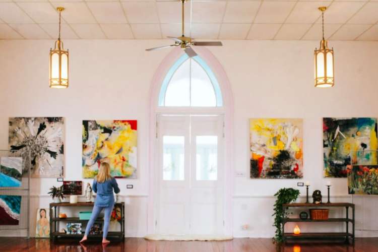 a bright yoga studio with colorful art hanging on its white walls