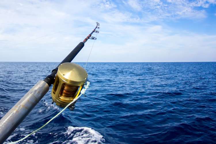 a rod and reel on a boat in the open blue ocean