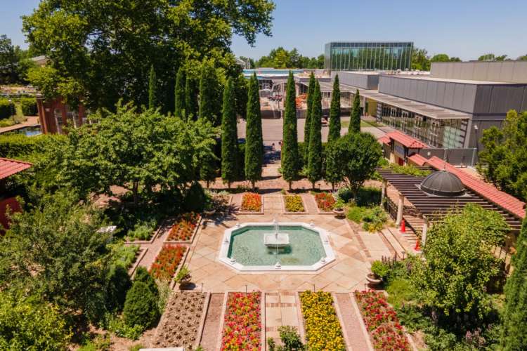 expansive view of a courtyard with fountain and decorative plants