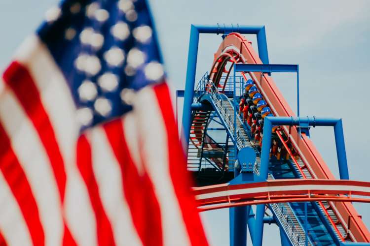 the American flag in front of a steep roller coaster