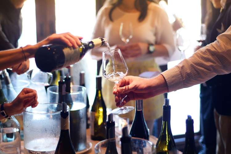 white wine being poured into a woman's glass