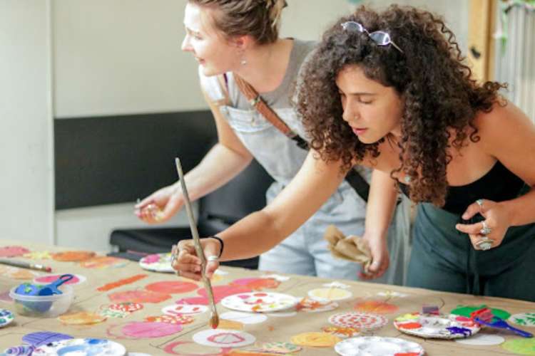 two artists creating paintings on a table