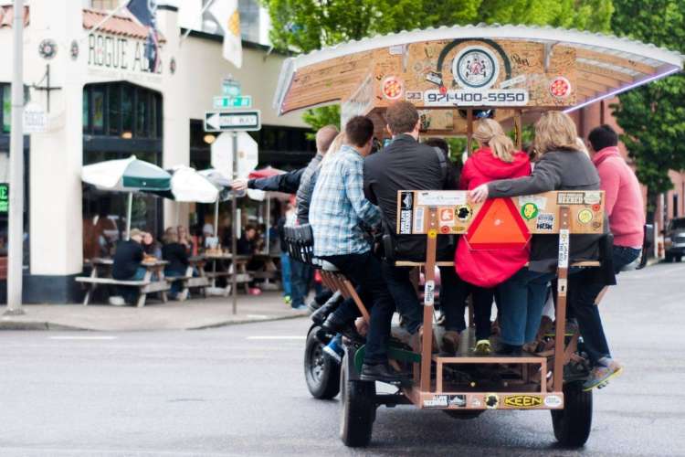 a group of people taking a beer tour on a multi-passenger beer bike in Portland