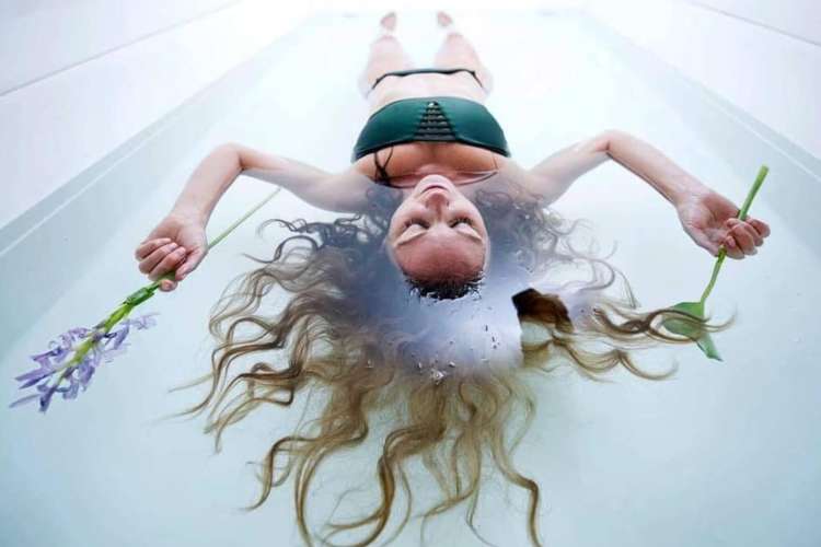 a woman floating in a sensory deprivation tank