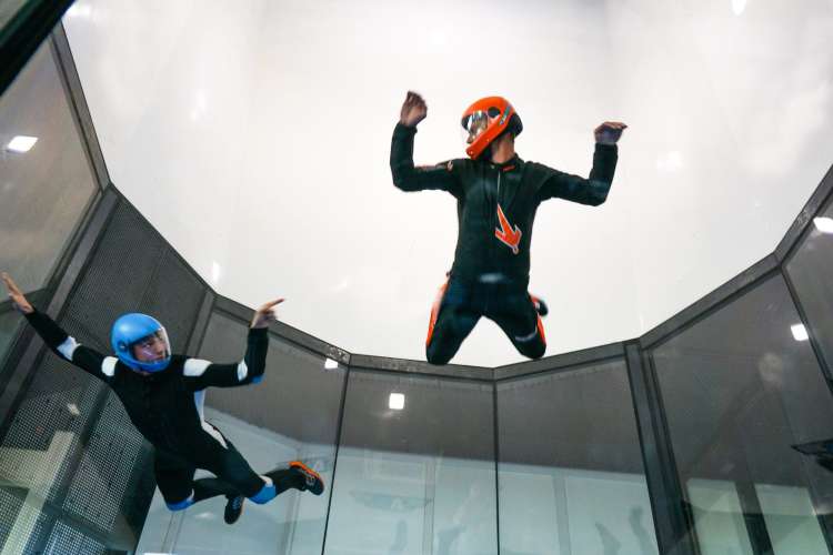 two people in the air doing indoor skydiving