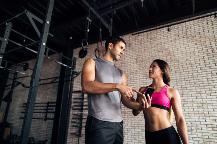 a man and woman chatting in a gym