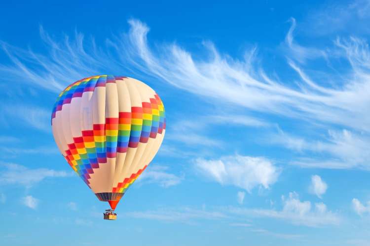 a colorful hot air balloon in flight on a clear, sunny day