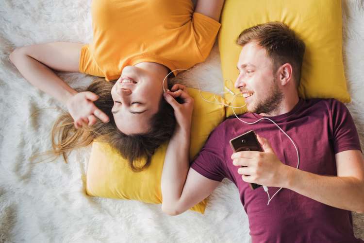 A couple layind down while listing to music together, which is a great one-year anniversary date idea