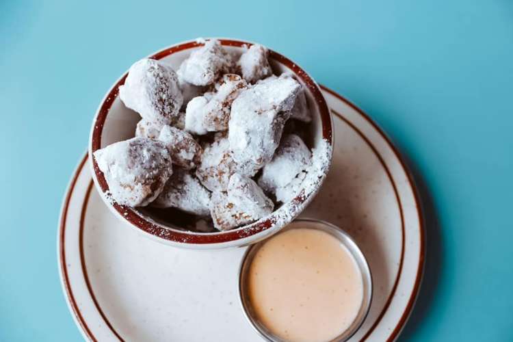 fried pork pieces with powdered sugar in a bowl