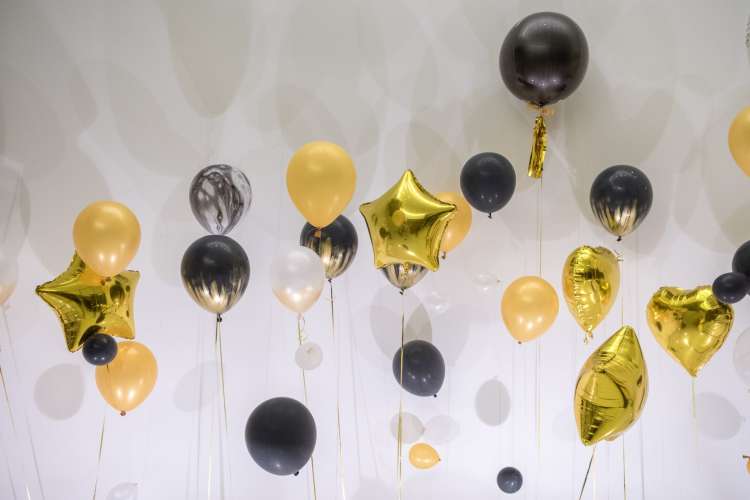 black and gold balloons decorate a wall