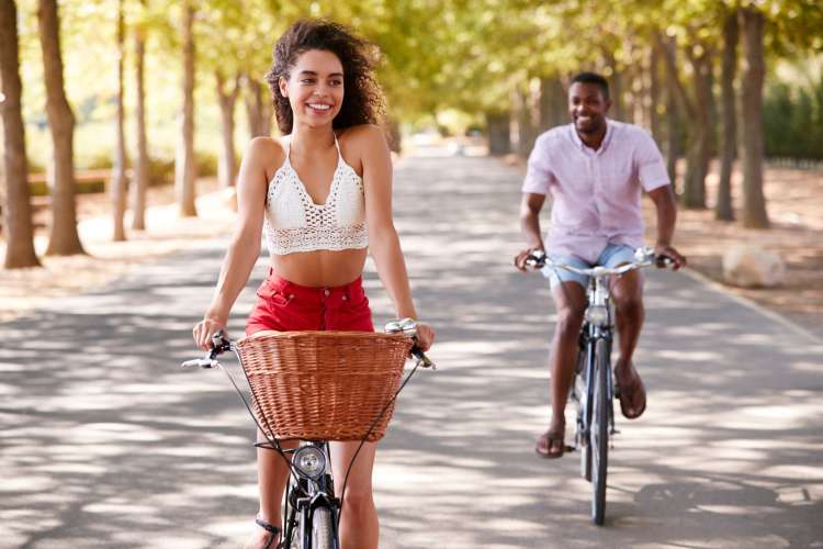A man and woman biking around town, which is a great first date idea