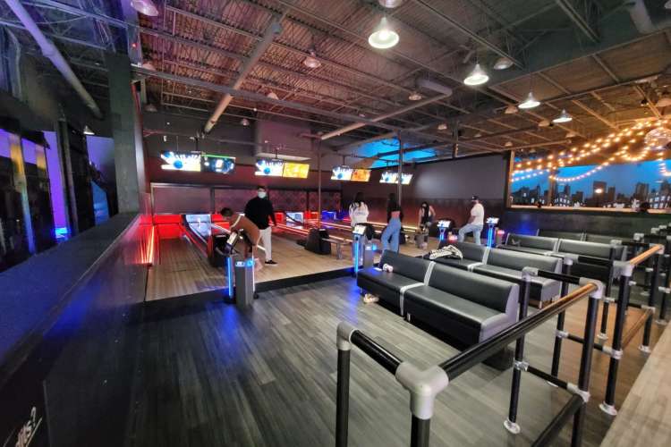 a bowling alley with wood floors and streamer lights