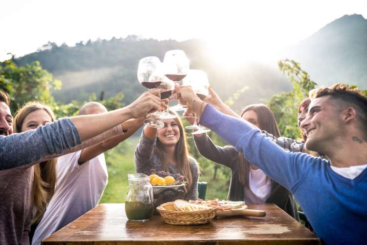 smiling people toasting with wine