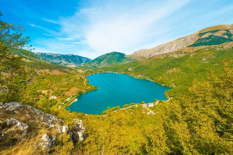 a blue lake surrounded by mountains below a crisp blue sky