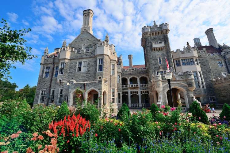 a grey stone, imposing Gothic mansion front