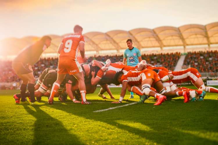 Austin Gilgronis rugby players in a huddle on the pitch