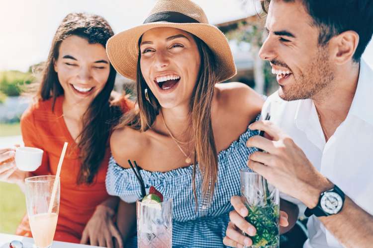 A woman laughing with two friends