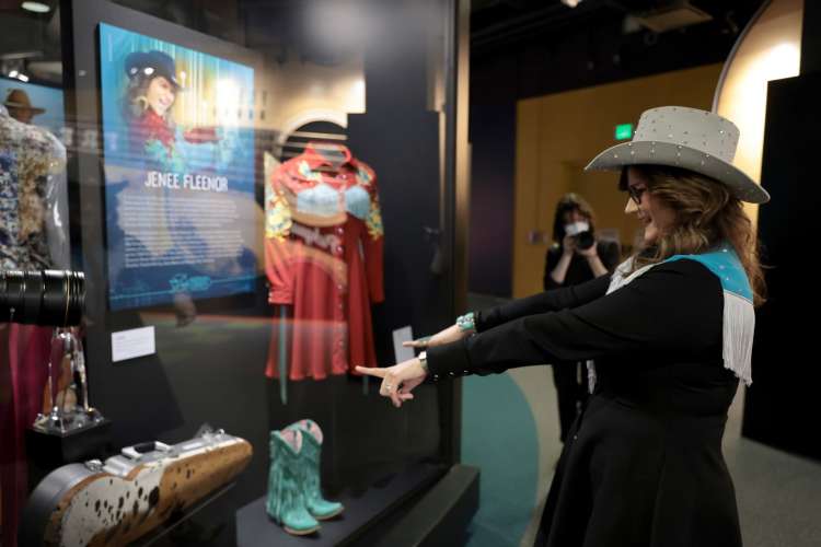 woman pointing excitedly at an exhibit in the country music hall of fame