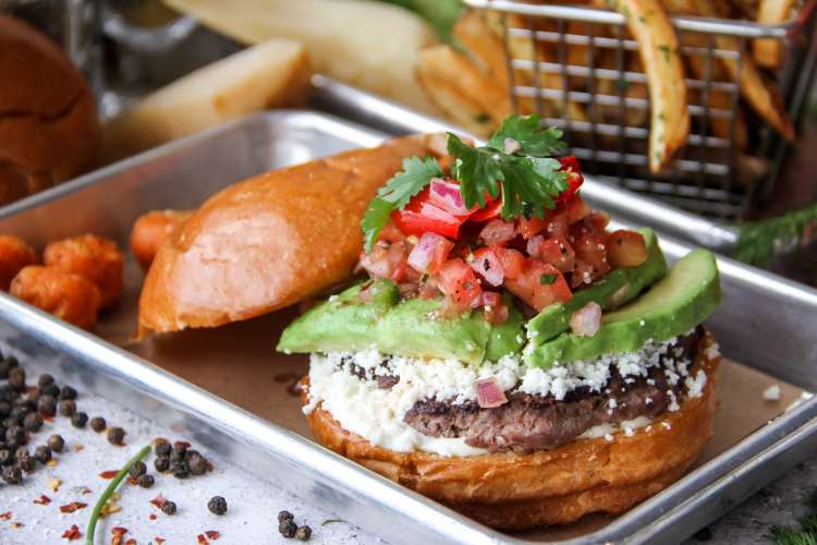 burger piled with avocado, pico de gallo, queso fresco, and cilantro from flip burger boutique