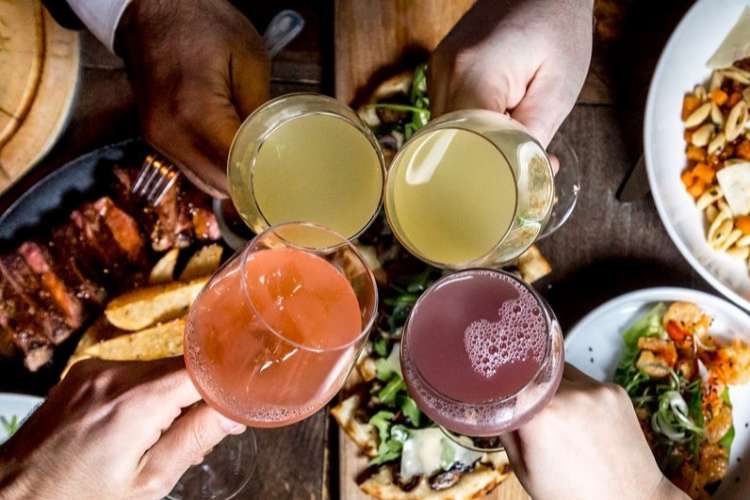 friends toasting juice or sangria glasses at hotel chantelle over brunch