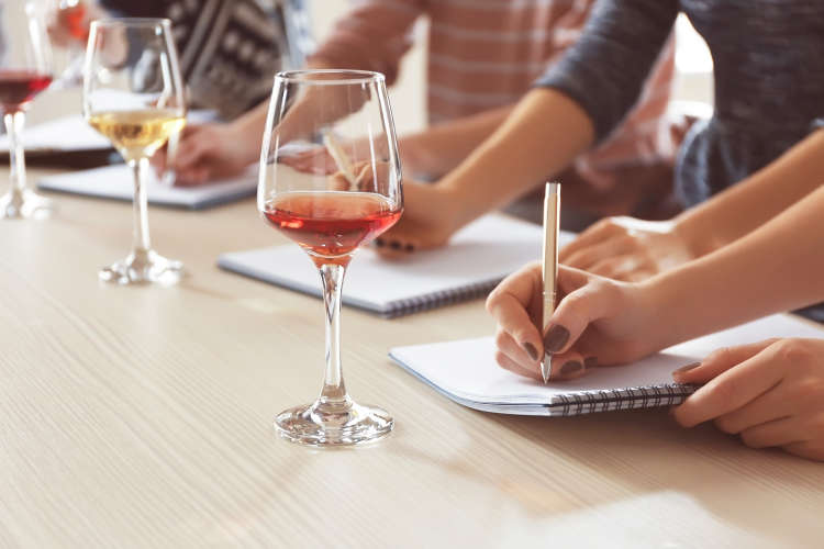 a wine taster writes in a notebook