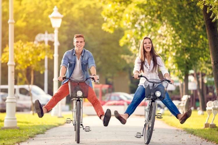 a couple riding bicycles together and laughing