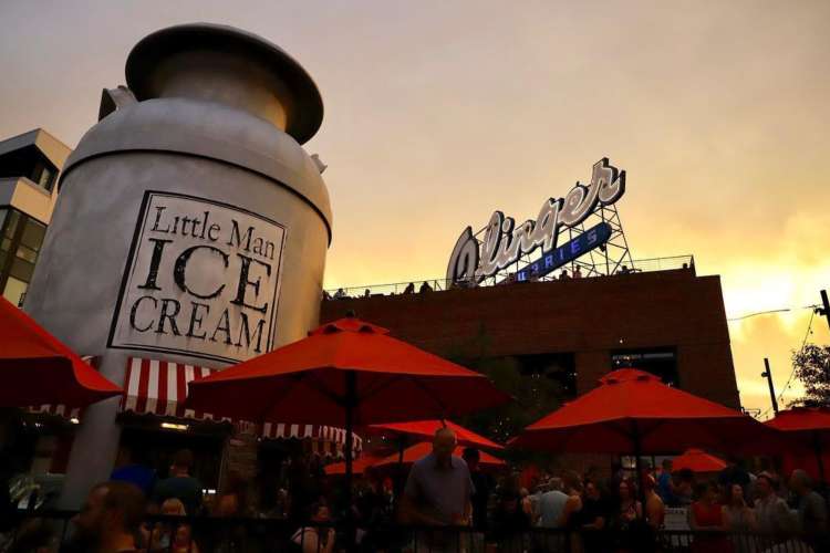 a large cylindrical building in a downtown setting that reads Little Man Ice Cream