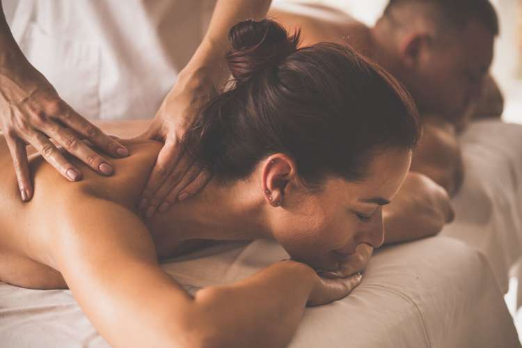 a woman and a man receive massages in a relaxing setting