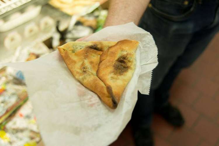 a food tour participant shows a piece of artisanal bread