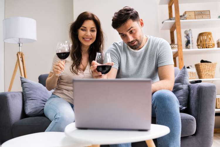 a woman and man drinking red wine during a virtual wine class