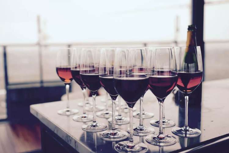 a group of glasses filled with red wine