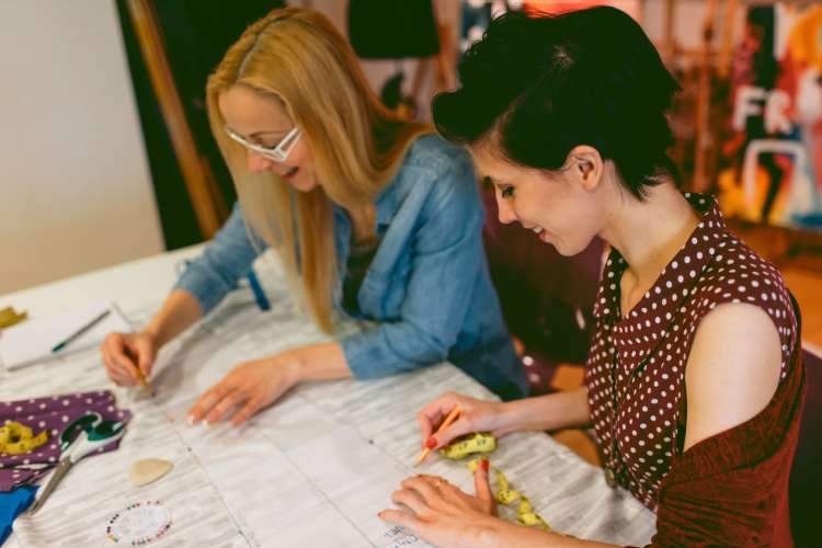 two women working at a table during a sewing class