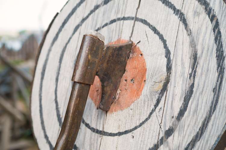 An axe stuck through a wooden target
