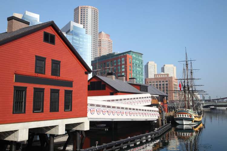 Boston Tea Party ship sitting in the harbor with Boston in background