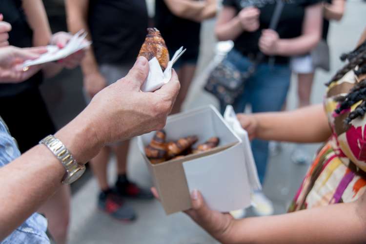 people enjoying pastries on a food tour