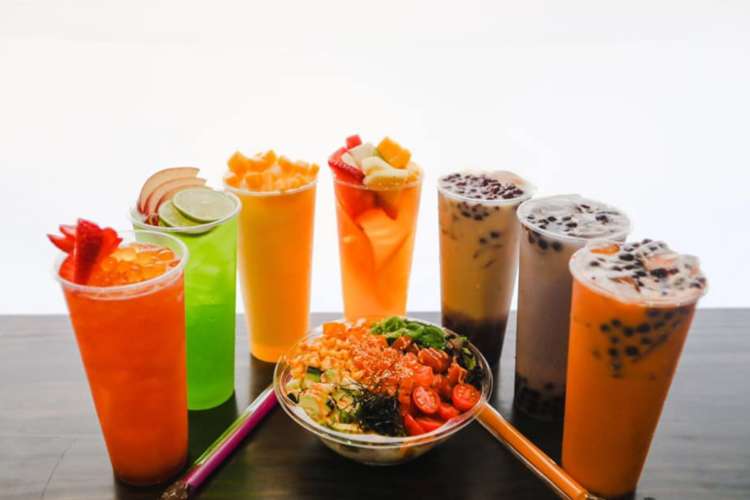 an array of boba tea and fruit teas and a bowl of salad