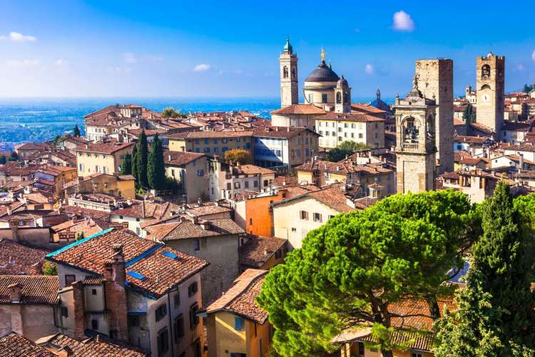 quaint towers and rooftops against a blue Lombardy sky