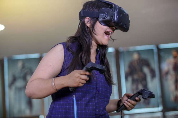 a woman with a VR headset on playing a game and smiling