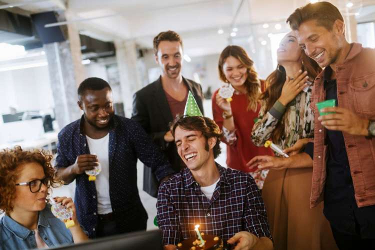 an employee celebrating a birthday surrounded by coworkers