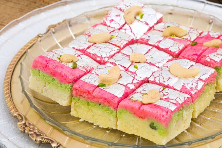 squares of yellow Indian barfi candy with pink tops